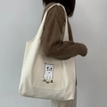 Sac fourre-tout minimaliste en toile beige avec chat mignon porté par un modèle - Beige