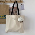 Dettaglio della borsa tote in tela crema con stampa FREEDOM e ciondolo a nuvola bianca - Borsa Beige con Lettere Piccole Con Ciondolo a Nuvola