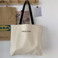 Dettaglio della borsa tote in tela con tracolla nera e testo Freedom stampato sul tessuto - Borsa Beige con Lettere Piccole (Senza Ciondolo)