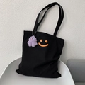 Detail van de zwarte canvas draagtas met oranje smileyprint en paarse pluche hanger - Zwart (Met Hanger)
