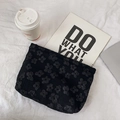 Vue détaillée de la trousse noire à texture florale 3D et tissu jacquard brodé de luxe - Noir