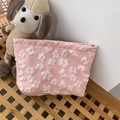 Détail de la texture jacquard florale sur une trousse rose avec chiot en peluche - Rose