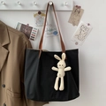Dettaglio della borsa tote in tela nera con manici in pelle e ciondolo a coniglietto - Con Ciondolo a Forma di Coniglio / Nero