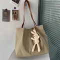 Dettaglio della borsa tote in tela con manici in pelle marrone e ciondolo a coniglio - Con Ciondolo a Forma di Coniglio / Cachi