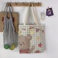 Detalle del bolso tote de lona con estampado de oso y textura de cuadros grises - Oso que Saluda Beige