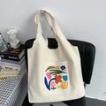 Minimalistische crème canvas draagtas met bloemenprint op zwart stoel - Onregelmatige Artistieke Bloemen