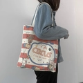 Detail view of canvas tote bag featuring red stripes and circus animal illustrations - Circus Acrobat Beige