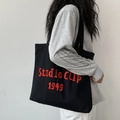 Schwarze Canvas-Einkaufstasche mit roter Studio Clip 1949 Stickerei und breitem Gurt - Schwarz mit Stickerei