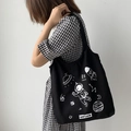 Detailaufnahme der schwarzen Canvas-Tasche mit Astronauten-Print über Karokleid getragen - Astronaut Schwarz