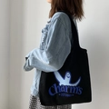 Detail einer schwarzen Canvas-Tasche mit blauem Grafikdruck über einer Jeansjacke - Westen-Stil Schwarz