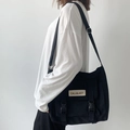 Détail du sac de messager en nylon noir avec bandoulière réglable sur un mannequin - Sans Pendentif / Noir