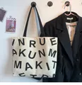Detail of canvas tote bag with bold lettering and durable black handles for travel - KUN Black Letters