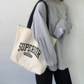 Detail of minimalist canvas tote bag with retro lettering and gray long-sleeved t-shirt - Superior Black Strap