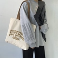 Detail of off-white canvas tote bag featuring brown retro Superior lettering and vintage style - Superior Light Khaki Strap