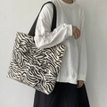 Primer plano del bolso tote de lona con patrón de cebra en una modelo femenina - Beige cebra