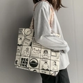 Große Canvas-Einkaufstasche mit Comic-Print und buntem Tweed-Gurt an einem Model gezeigt - Beige