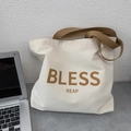 Dettaglio della borsa tote in tela crema con manici marroni e scritte BLESS REAP - Stile Orizzontale con Tracolla Cachi BLESS