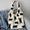 Détail d'un sac cabas en toile blanche avec motifs d'ours noirs sur un canapé - Beige Ours