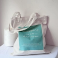 Dettaglio della borsa tote in tela bianca con stampa grafica verde acqua e testo d'arte - Blocco di Colore Blu Menta (Shopping is an ART Form) / Azzurro (Shopping)