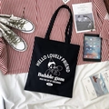 Flat lay of black canvas tote bag featuring bubble blowing cartoon print and casual props - Black Blowing Bubbles Boy Shoulder Bag