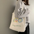 Detail der cremeweißen Canvas-Einkaufstasche mit bunten Smileys und Schreibschrift - Frische Smiley-Weste Stil Tasche