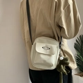 Detail of off-white canvas crossbody bag with planet logo and green frog plush charm - Off White
