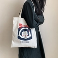 Detail der weißen Canvas-Tasche mit Retro-Print getragen auf der Schulter über schwarzem Kleid - Weiße Food Factory Girl Umhängetasche