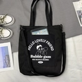Détail du sac en toile noire montrant la poche extérieure contenant une tablette - Garçon à Bulles Noir (Double Usage)