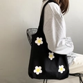 Detail der schwarzen Canvas-Tragetasche mit weißen Gänseblümchen auf dem Modell - Schwarz