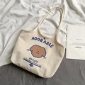 Gros plan du sac cabas en toile beige avec motif chien et bouton pression en métal - Imprimé Chien Adorable Crème