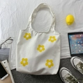 Detailansicht der weißen Canvas-Tasche mit gelben Blumenprints und Lifestyle-Dekor - Weiß