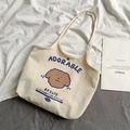 Detail of canvas tote bag featuring cute cartoon dog print and adorable blue text phrases - Cream Adorable Dog Print