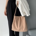 Detail view of khaki nylon tote bag with metal snap closure on a minimalist background - Light Khaki