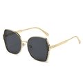 Schicke goldene Polygon-Sonnenbrille mit schwarzem Steppmuster am Bügel und grauen Gläsern - Goldrahmen Schwarzgrau