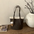 Detail of dark brown suede bucket bag with white faux shearling trim and glove charm - Brown