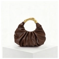 Detail of brown pleated cloud bag featuring a unique curved gold metallic handle - Brown