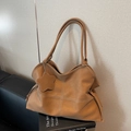 Borsa tote vintage marrone con cuciture a contrasto e ciondolo a stella su sfondo moderno - Marrone