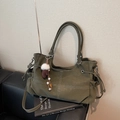 Olive green tote bag with contrast stitching and decorative charms on a sofa - With Charm / Green