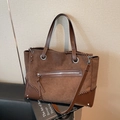 Retro brown tote bag with contrast leather trim on a sofa in a minimalist room - Coffee