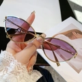 Occhiali da sole cat-eye con montura in metallo dorato e lenti sfumate viola in mano - Montatura Dorata Lenti Grigio Marrone