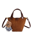 Sac seau en cuir brossé marron avec poignée et charmant pendentif chiot en peluche - Avec Pendentif / Marron / Sac À Main En Daim Marron Texturé Avec Des Bords Huilés Marron Foncé Sur Les Anses Et Un Charm En Forme De Chien En Pull Tricoté.