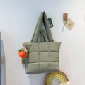 Sage green quilted puffer tote bag with decorative persimmon pendant on a wall hook - With Pendant / Green