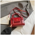 Detail of dark red glossy leather handbag with gold metal logo and adjustable strap - Basic Style / Red