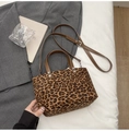 Detail of leopard print tote bag with brown leather handles and adjustable strap on white linen - Leopard Print No Charm