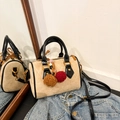 Beige suède Boston-tas met zwarte handvaten en pluche bedeltjes op denim jas - Met Hanger / Khaki