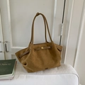 Bolso tote grande de ante marrón con hebilla dorada y cordón sobre sofá blanco - Marrón
