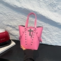 Borsa a secchiello punk rosa con borchie argentate e ciondolo a croce vista a mano - Rosa