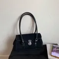Detail of black faux suede shoulder bag featuring contrast stitching and silver buckle - Black
