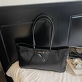 Detail van zwarte matleren shopper met stijlvolle gesp en dubbele slanke handvatten - Zwart
