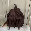 Détail du sac à dos en daim marron avec clous argentés et fermeture à cordon - Marron